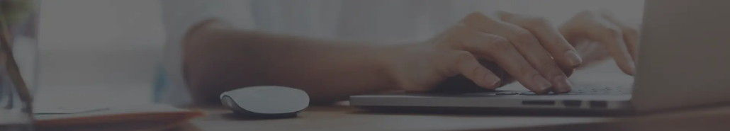 Hands typing on a laptop
