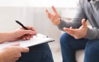 Psychologist taking notes during a session with a client