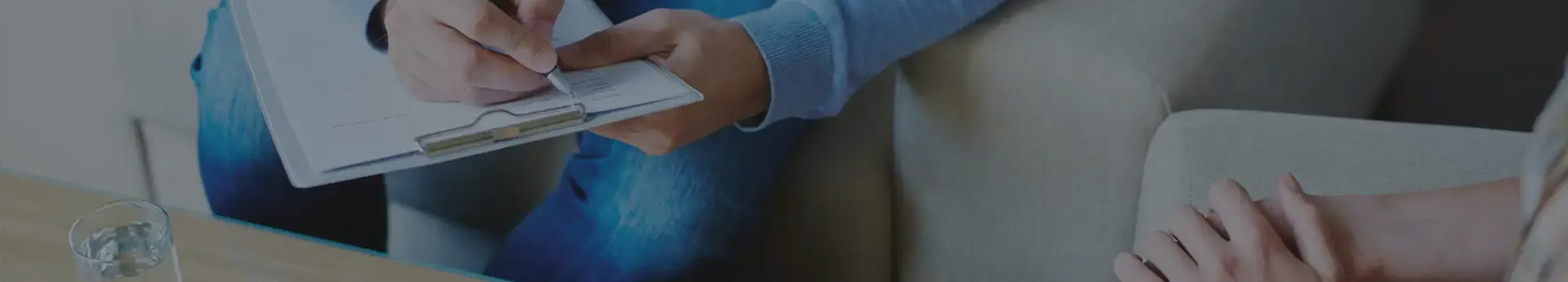 Hands writing on a clipboard during a session